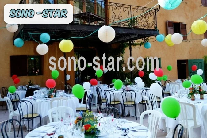 Réception de mariage en extérieur décorée de lanternes et de ballons colorés